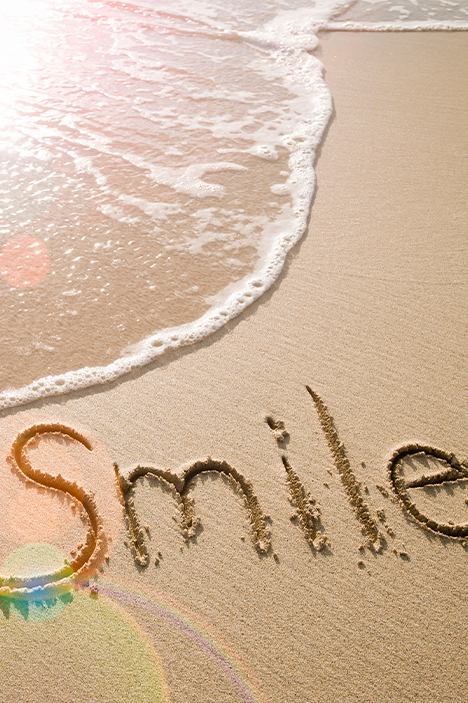 The word smile written in sand at beach