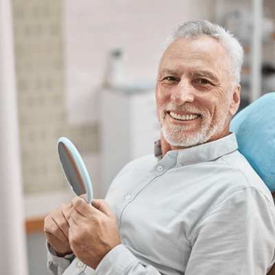 a patient smiling after receiving his dental crown