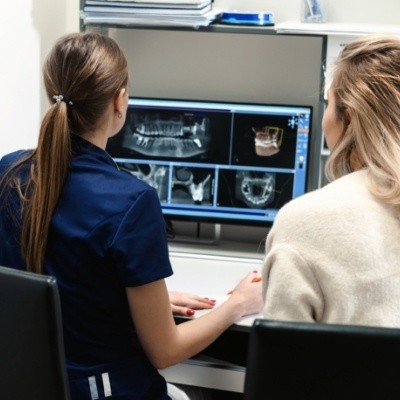 Dental team member showing a patient digital dental x rays of their mouth