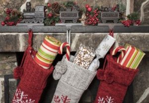 Three stockings full of presents hanging on a mantle